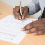 Photo by Cytonn Photography from Pexels: https://www.pexels.com/photo/person-holding-gray-twist-pen-and-white-printer-paper-on-brown-wooden-table-955389/